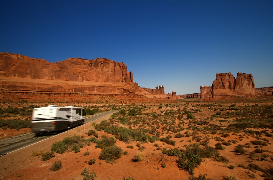 Summer vacation travelers tour through Arches National Park in U